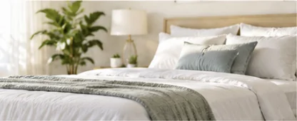 Freshly made bed in a bright, empty-feeling bedroom